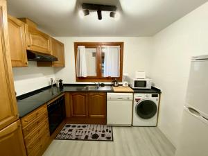 a kitchen with a sink and a washing machine at NÓRDIKA - Appartement chaleureux 10' des pistes in El Tarter