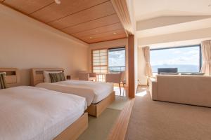 One Niseko Resort Towers في نيسيكو: غرفة نوم بسريرين ومكتب واريكة