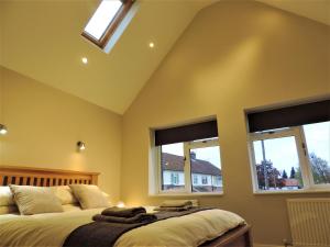 two beds in a bedroom with two windows at 3 Bed Farnborough Air Accommodation in Farnborough