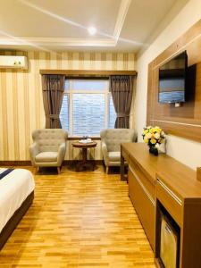 Habitación de hotel con cama, escritorio y sillas en Khách sạn Ngọc Thành 2, en Rạch Giá