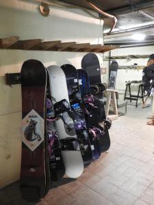 a bunch of snowboards are lined up on a wall at Brocken Hutte in Hakuba