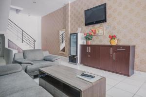 sala de estar con sofá y TV en RedDoorz @ Jalan Hayam Wuruk Lampung 2, en Bandar Lampung