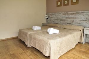 
a hotel room with a bed and a dresser at Aparthotel La Vall Blanca in Vielha
