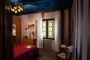 1 dormitorio con cama roja y ventana en Casa di Pierina en Poggibonsi