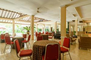 een restaurant met tafels en stoelen in een kamer bij RedDoorz @ Jalan lintas Sumatera Lahat in Lahat