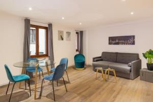 a living room with a couch and a table and chairs at Travel Homes - L'Arsenal, studios en hyper centre in Mulhouse