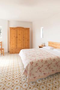 a bedroom with a large bed and a wooden cabinet at Albergo Villa Mario in Ischia