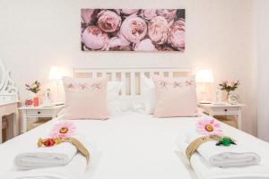 ein Schlafzimmer mit einem weißen Bett mit rosa Blumen drauf in der Unterkunft Apartment Sol Gran Vía in Madrid