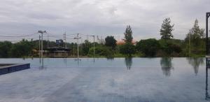 a large pool of water with trees in the background at Proud Khaoyai in Pak Chong