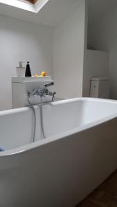 d'une baignoire blanche avec un robinet. dans l'établissement Le HWell, à Saint-Valery-sur-Somme