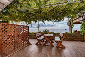 a table and chairs on a deck with the ocean at Hotel Savojo in Petrovac na Moru