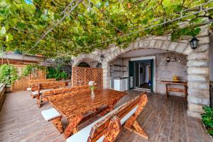 a wooden table and benches on a patio at Hotel Savojo in Petrovac na Moru