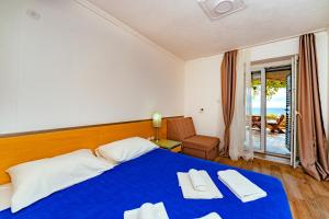 a bedroom with a blue bed with a view of the ocean at Hotel Savojo in Petrovac na Moru