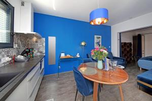 ガイヤックにあるbleu nuit studioの青い壁のリビングルームとキッチンが備わります。