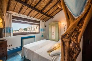 um quarto com uma cama grande e uma janela em Hotel Anticos Palathos em Orosei