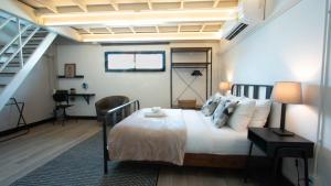 een slaapkamer met een groot bed en een trap bij Airee Premier Residence in Bangkok