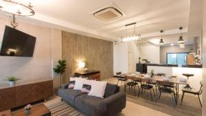 een woonkamer met een bank en een tafel bij Airee Premier Residence in Bangkok