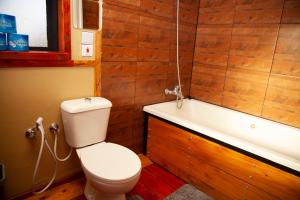 a bathroom with a toilet and a bath tub at Shamba lodge in Arusha