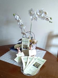 una mesa con un jarrón de flores y libros en CASCINA PONTETTO, en Asti