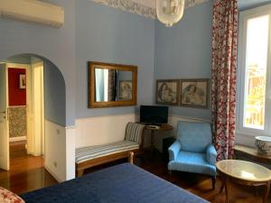 a living room with a blue chair and a television at Relais Teatro Argentina in Rome
