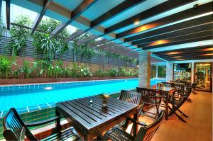 Aspen Suites Hotel Sukhumvit 2 في بانكوك: مسبح بالطاولات والكراسي بجانب مسبح