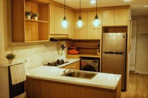 uma cozinha com um lavatório e um frigorífico de aço inoxidável em Graha Padma Avonia em Semarang