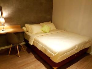 niewielka sypialnia z łóżkiem i biurkiem w obiekcie Graha Padma Avonia w mieście Semarang