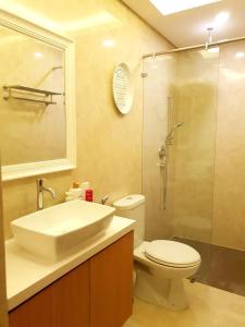 een badkamer met een wastafel, een toilet en een douche bij Graha Padma Avonia in Semarang