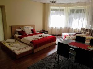 a bedroom with two beds and a table and a desk at Filaretai Exclusive in Vilnius