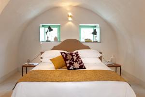 a bedroom with a large bed and a large window at Relais Terre di Romanello in Noto