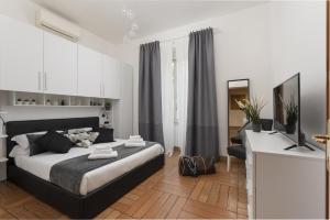a bedroom with a bed and a desk with a television at Take You Rome - Vatican Apartment in Rome