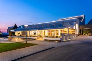 un grand bâtiment avec un éclairage de rue la nuit dans l'établissement Hotel Nais, à Niš