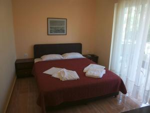 a bedroom with a bed with two towels on it at Olympic Bibis Hotel in Metamorfosi