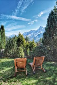 dos sillas de madera sentadas en la parte superior de un campo en Thendia Montblanc, en Les Houches