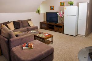 a living room with a couch and a refrigerator at Yungaburra Heart B & B in Yungaburra