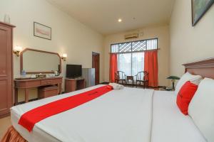 a bedroom with a large bed with a desk and a mirror at RedDoorz near Transmart Pangkal Pinang in Pangkal Pinang