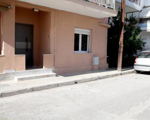 a building with stairs and a car parked in front at Hope home in Volos