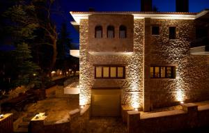 a large stone building with a garage at night at Mysaion Hotel in Synikia Mesi Trikalon