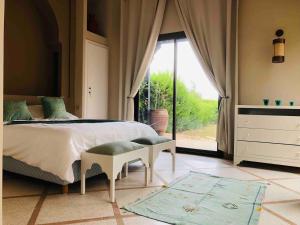 - une chambre avec un lit et une grande fenêtre dans l'établissement Villa Mayrit, Villa estilo Riad en un entorno único, à Marrakech