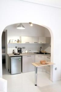a kitchen with white cabinets and a table in it at Hope home in Volos