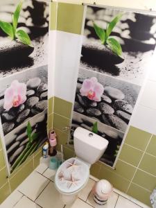 uma casa de banho com WC e flores na parede em Maison de la plage em Trois-Rivières