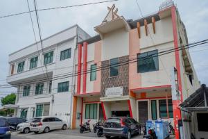 a building with cars parked in front of it at RedDoorz near Monumen Habibi Ainun in Parepare