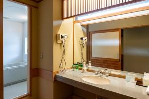 un bagno con lavandino e specchio di Kurobe View Hotel a Ōmachi