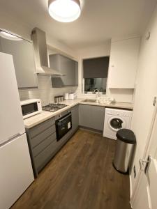 a kitchen with white cabinets and a white appliance at Apartment 20 @ Excel London in London +17 photos