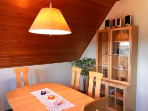 a dining room with a table and a yellow light at MAL Steinbock _ Ferienwohnung Anni in Malente