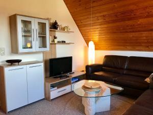 - un salon avec un canapé et une télévision dans l'établissement MAL Steinbock _ Ferienwohnung Anni, à Malente