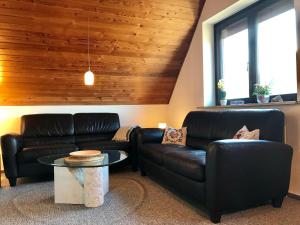 a living room with two leather couches and a table at MAL Steinbock _ Ferienwohnung Anni in Malente