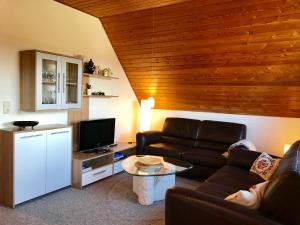 a living room with a couch and a tv at MAL Steinbock _ Ferienwohnung Anni in Malente