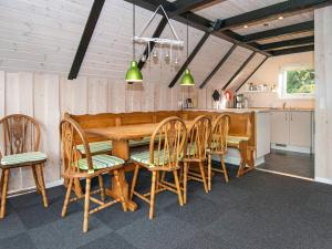 a dining room with a wooden table and chairs at 6 person holiday home in R m in Toftum