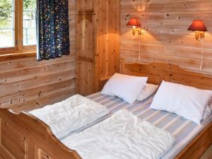 two beds in a room with wooden walls at 4 person holiday home in olden in Olden